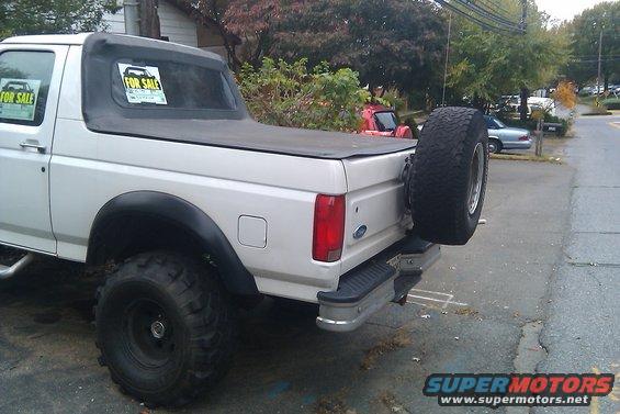 White 1996 Ford Bronco soft top with spare tire on rear bumper