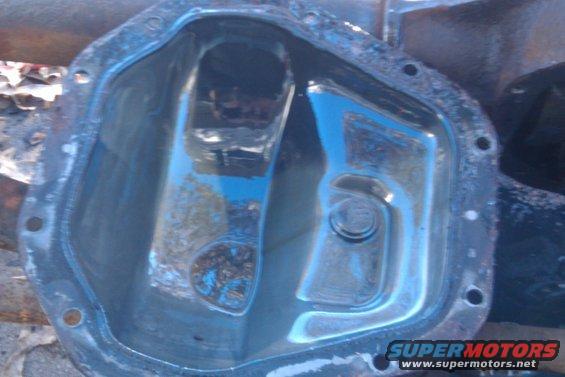 Differential cover with blue fluid and debris inside. Watermark reads SUPERMOTORS