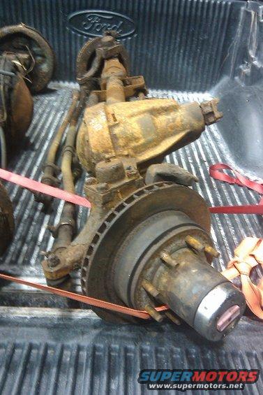 Ford Bronco front axle assembly with brake rotor and hub, rusted, in truck bed