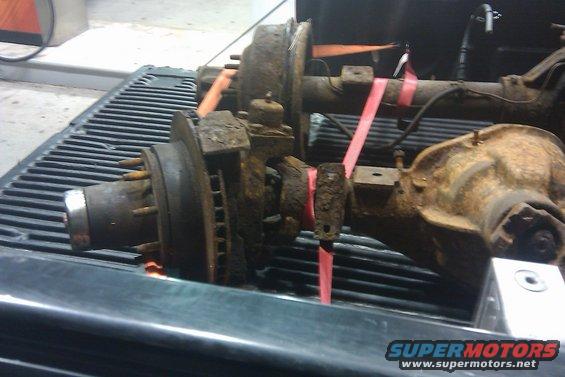 Rusty front and rear axles with disc brakes on a truck bed