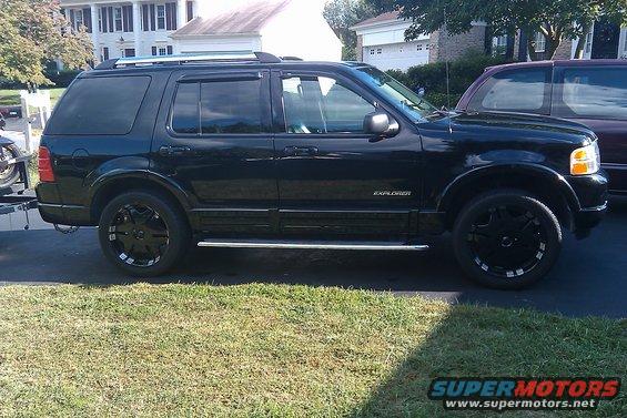 Black Ford Explorer SUV side view with custom black rims and chrome running boards