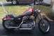2004 Harley-Davidson Sportster Custom - This Harley-Davidson motorcycle features a two-tone red and silver fuel tank with the brand's logo visible.