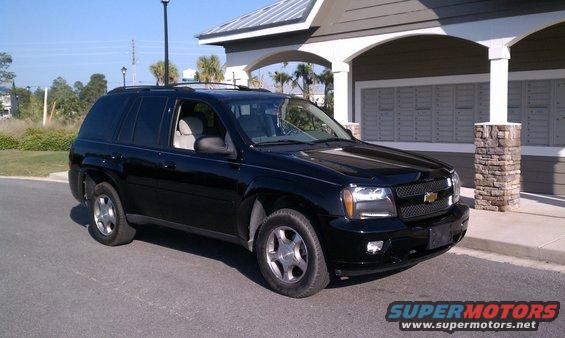 Black 2008 Chevrolet TrailBlazer parked in front of a building with stone pillars