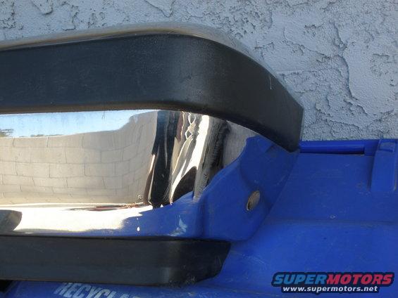 Chrome bumper section with black trim, resting on blue plastic