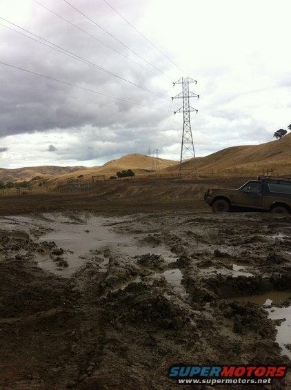 Brown 1990 Ford Bronco stuck in mud, side view