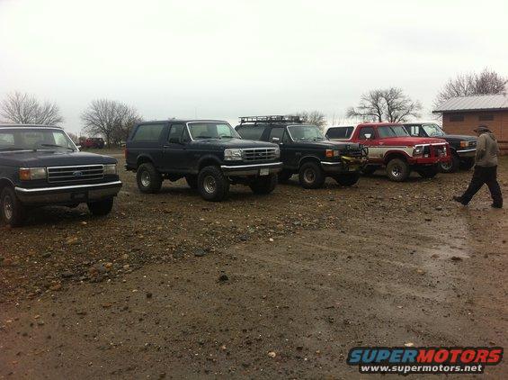 1990 Ford Bronco and other SUVs/trucks parked on gravel lot