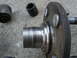 1995 Ford Thunderbird - A close-up view of a vehicle's wheel hub assembly and associated hardware, including lug nuts and a socket, resting on a concrete surface.