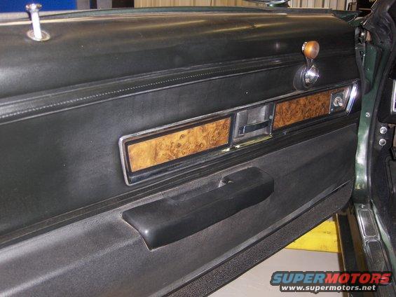 1970 Chevrolet Camaro interior door panel with wood grain trim and black armrest