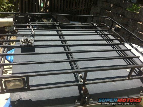 Custom metal roof rack mounted on a dark-colored vehicle top