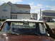 2005 Ford Excursion - Hands are adjusting the roof of a brown truck cab with a "XTREME ABUSE" sticker on the rear window.