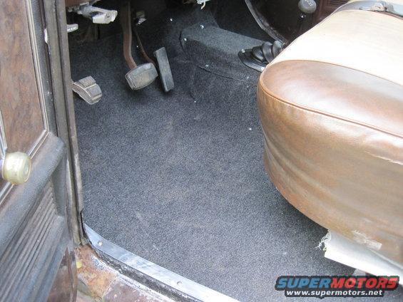 Interior floor and passenger seat of a vehicle, showing pedals and carpeting