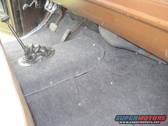 1979 Ford Bronco interior floor showing grey carpet, floor shifter, and pedals