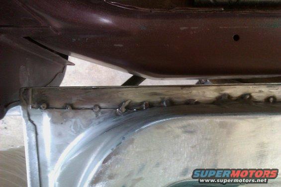 Close-up of a metal panel repair with visible welds