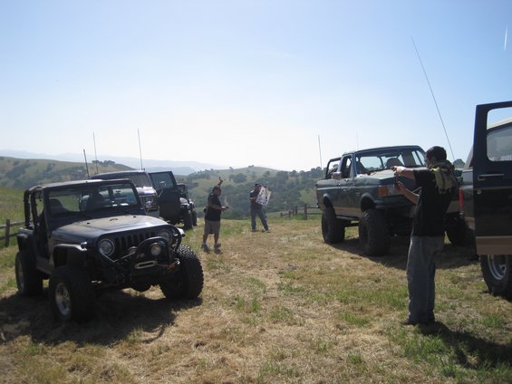 Green lifted 1989 Ford Bronco with people gathered around
