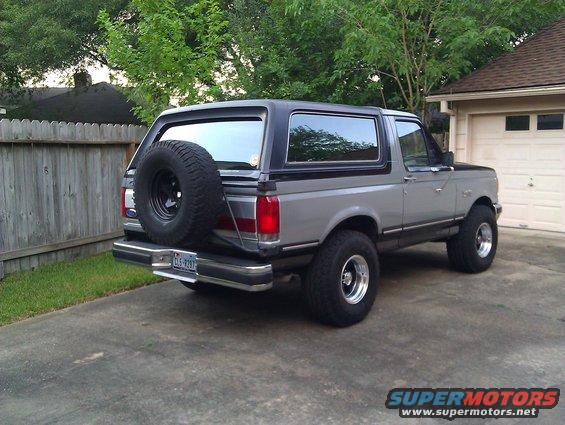 Gray Ford Bronco with spare tire on rear, parked in driveway