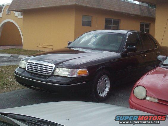 Black 2001 Ford Crown Victoria parked next to a red car and a white car