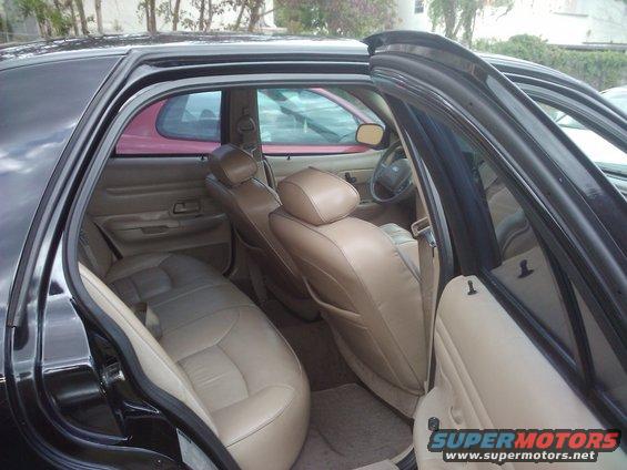 Interior of black sedan with tan seats, showing rear and front seats