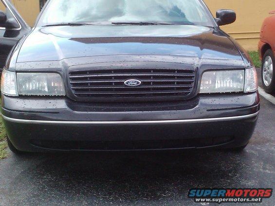 Front view of a black 2001 Ford Crown Victoria. It has a chrome grille with a Ford logo