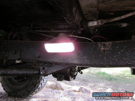 underbody of a vehicle showing a frame rail and a bright light