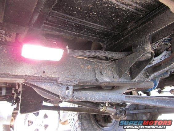 Vehicle undercarriage with a pink light and visible suspension components