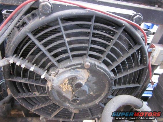 Electric cooling fan with black blades and a central motor housing, wires attached