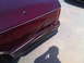 1993 Lincoln Town Car - The rear of a maroon vehicle shows significant damage to the quarter panel and bumper area.