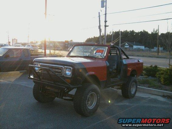 Red and black 1978 International Scout II with off-road tires and a front brush guard
