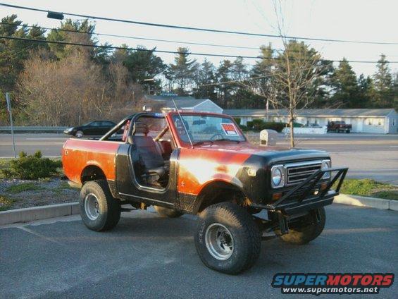 Red and black 1978 International Scout II with off-road tires and brush guard