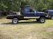 1994 Ford Explorer - Side view of a blue pickup truck with a custom flatbed and toolboxes, parked outdoors.