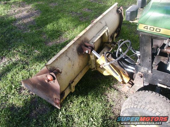 Tractor front with snow plow attachment. Green hood has '400' visible