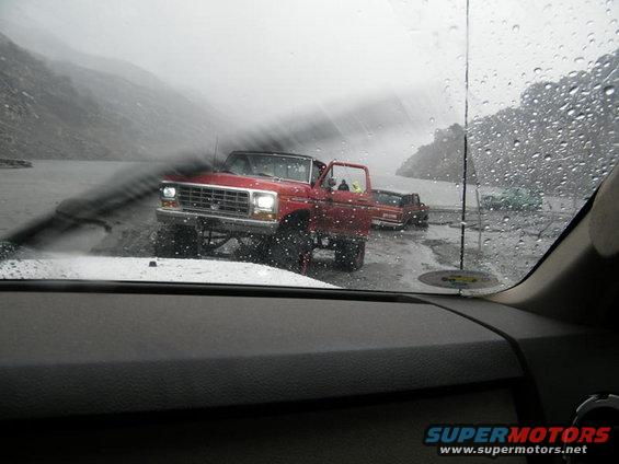 1978 Ford Bronco and another Ford truck in the rain