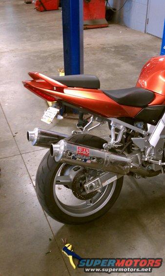 Orange motorcycle rear with dual Yoshimura exhaust