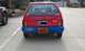 1991 Ford Festiva - Rear view of a red 1991 Ford Festiva with a blue bumper and a license plate.