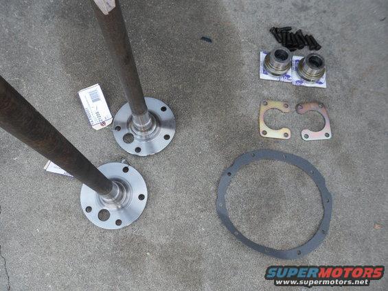 Axle shafts and differential parts laid out on concrete