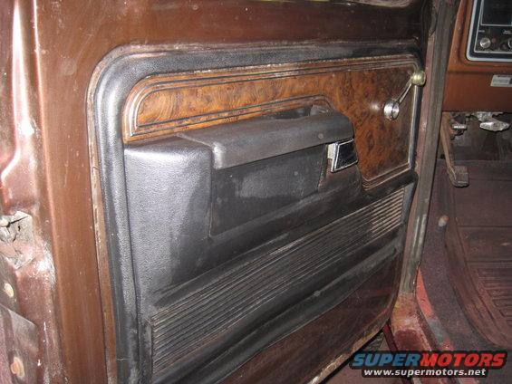 1979 Ford Bronco interior door panel with wood grain trim and black armrest