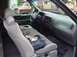 2001 Ford F-150 - The interior of a 2001 Ford F-150 pickup truck is visible, with a jacket on the passenger seat and other vehicles outside.