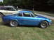 1977 Pontiac Trans Am - A blue coupe is parked on a grassy area with trees in the background and other cars nearby.