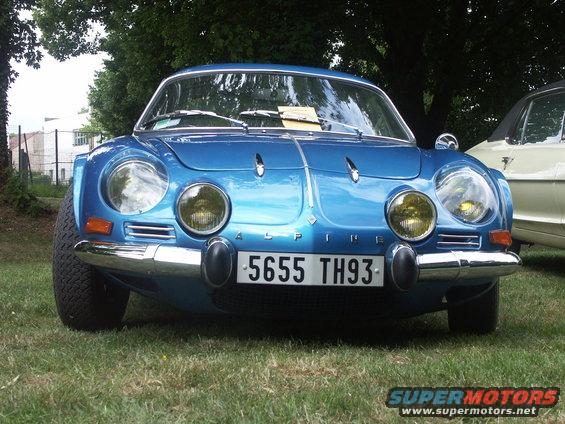 Blue Alpine car with yellow headlights and license plate 5655 TH93 parked on grass