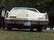 1977 Pontiac Trans Am - The rear of a cream-colored Lincoln Continental Mark V is visible, a spare tire cover and a French license plate.