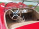 1977 Pontiac Trans Am - Interior of a vintage red sports car, a wood steering wheel and tan seats.