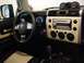 2010 Toyota FJ Cruiser - The interior of a 2010 Toyota FJ Cruiser features a beige dashboard panel surrounding the radio and climate controls.