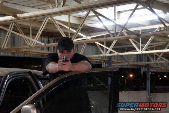 Man aiming handgun from open car door