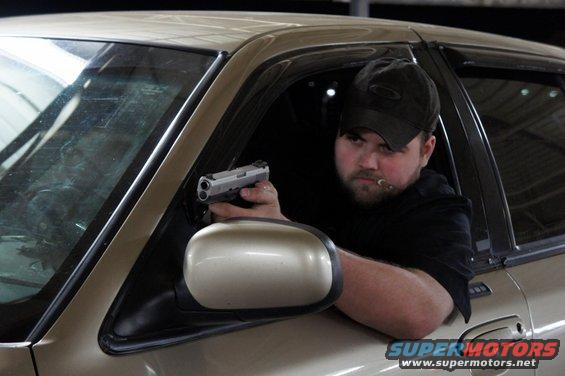 Man with handgun in car interior