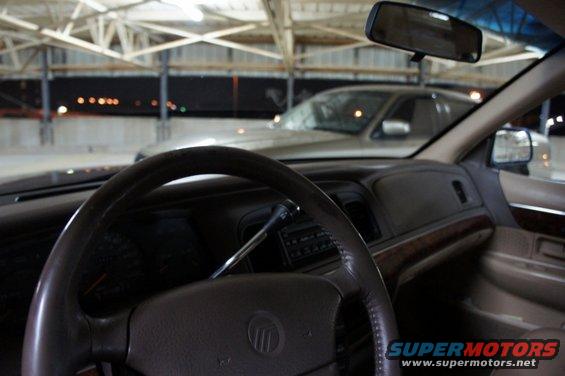 Interior shot of a 2000 Mercury Grand Marquis, looking out the windshield at another car parked nearby