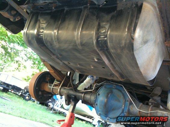 Undercarriage view showing fuel tank, rear axle, and drum brake assembly