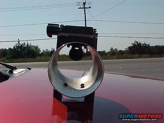 Red car hood with chrome exhaust pipe and black bracket