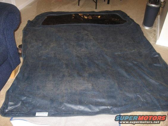 Dark blue car cover with a clear plastic window, labeled 'SPYDER', lying on the floor