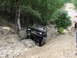 1967 Ford Mustang - A black off-road vehicle tackles a challenging rocky terrain on a wooded trail.