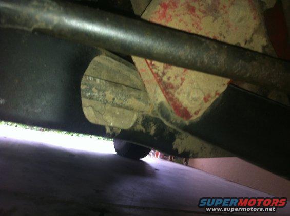 Underside view of vehicle suspension with red paint visible