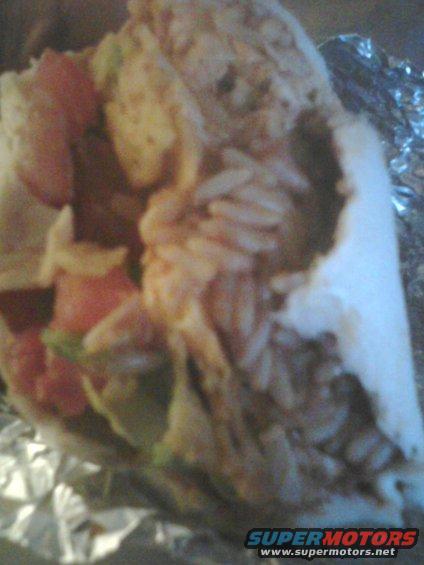 Burrito with rice, tomatoes, and lettuce wrapped in foil